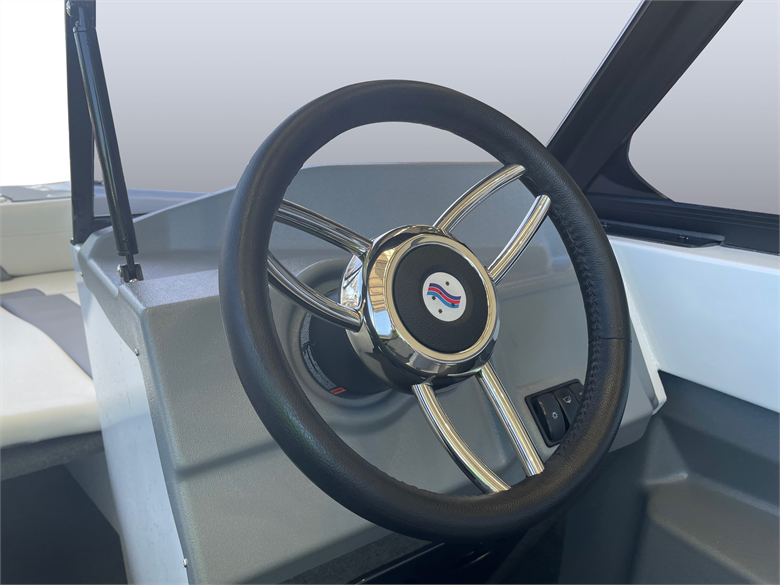 black steering wheels on a boat with a rubber grip and stainless spoke