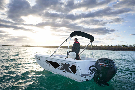 small white frontier boat anchored with a mercury outboard motor sailing on a water